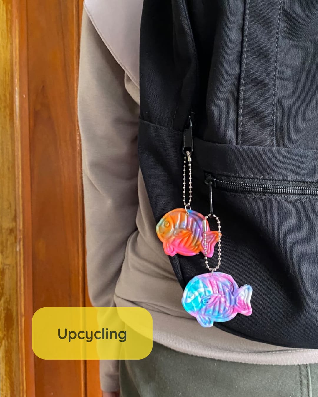 Gantungan kunci berbentuk ikan dari tutup botol plastik hasil upcycling yang digunakan sebagai aksesori tas.